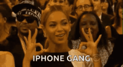 A Woman Is Giving An Ok Sign In Front Of A Crowd Of People With The Words Iphone Gang Written Below Her GIF