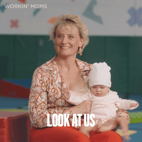 A Woman Is Holding A Baby And The Words Look At Us Are On The Bottom GIF