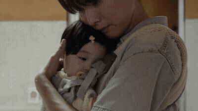a woman is holding a baby in a carrier