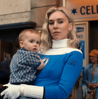 A Woman Is Holding A Baby In Front Of A Sign That Says Cele GIF