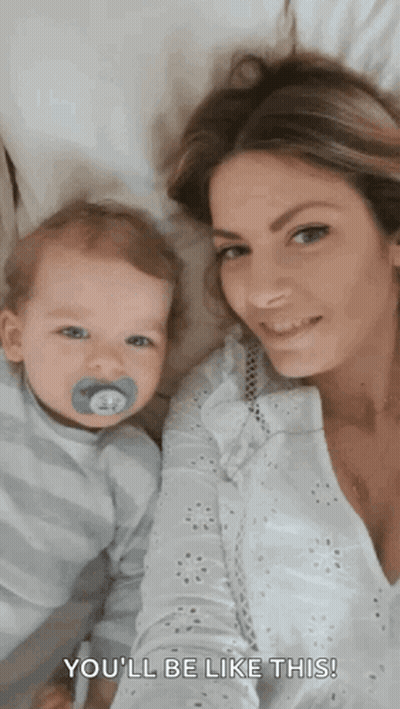 A Woman Is Holding A Baby With A Pacifier In His Mouth And Says " You 'Ll Be Like This " . GIF