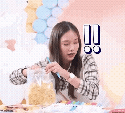 A Woman Is Holding A Bag Of Chips And A Pencil . GIF