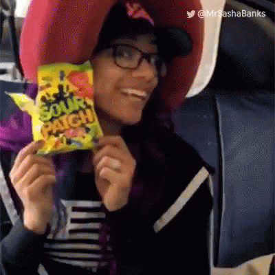 A Woman Is Holding A Bag Of Patch Candy And Smiling GIF