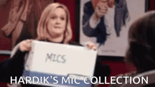 A Woman Is Holding A Binder With The Word Mic Written On It . GIF