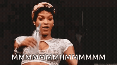 A Woman Is Holding A Bottle Of Water In Her Hand And Making A Face . GIF