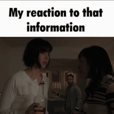 A Woman Is Holding A Bottle Of Wine And Talking To Another Woman GIF