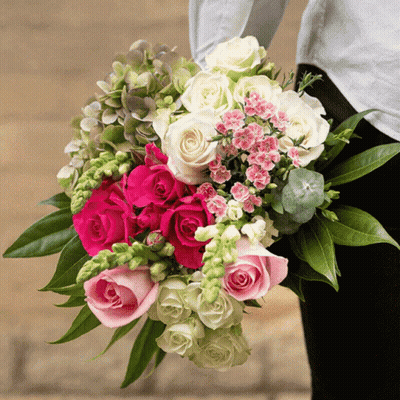 A Woman Is Holding A Bouquet Of Pink And White Roses GIF