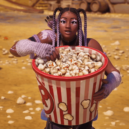 A Woman Is Holding A Bucket Of Popcorn With A G On It GIF