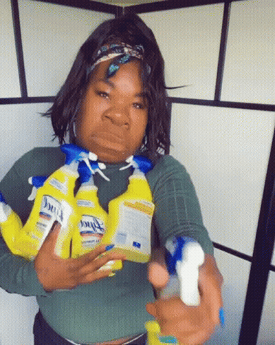 A Woman Is Holding A Bunch Of Clorox Spray Bottles In Her Hands GIF
