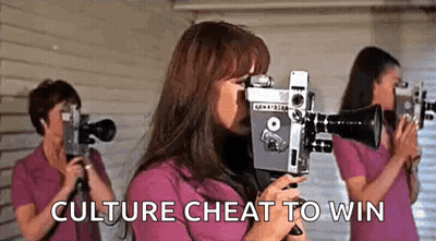 A Woman Is Holding A Camera In Front Of Her Face While Two Other Women Are Holding Cameras In Front Of Their Eyes . GIF