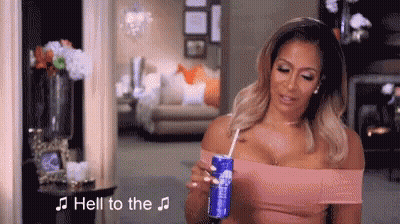 A Woman Is Holding A Can Of Soda Through A Straw In Her Hand . GIF