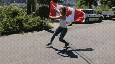 A Woman Is Holding A Canadian Flag In Her Hands GIF