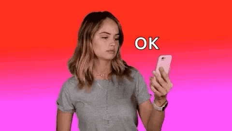A Woman Is Holding A Cell Phone In Her Hand . GIF