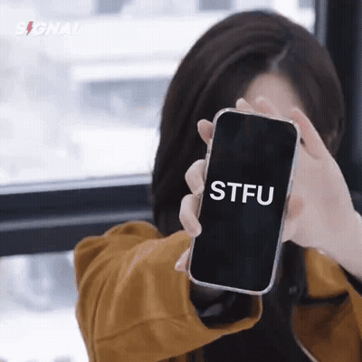 A Woman Is Holding A Cell Phone That Says Stfu On It GIF