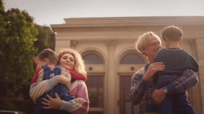 A Woman Is Holding A Child With The Letter E On It GIF