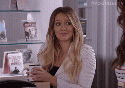 A Woman Is Holding A Coffee Mug That Says Message From Munich GIF
