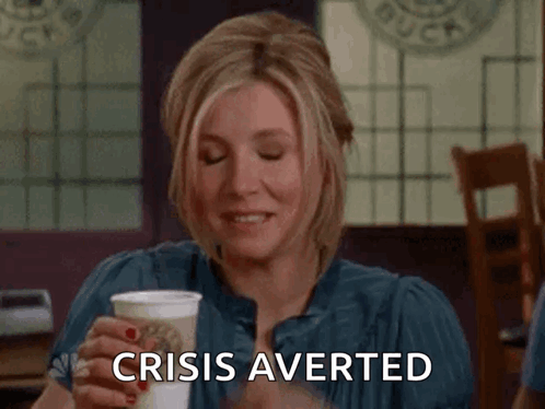 A Woman Is Holding A Cup Of Coffee And Saying Crisis Averted . GIF