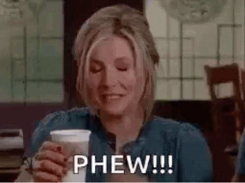 A Woman Is Holding A Cup Of Coffee And Smiling While Saying Phew . GIF