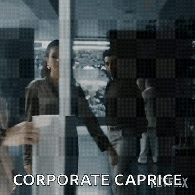 A Woman Is Holding A Cup Of Coffee While Standing Next To A Man In A Dark Room . GIF