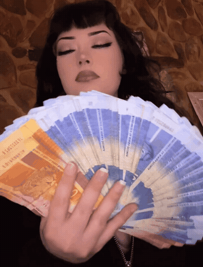 A Woman Is Holding A Fan Of Money That Says ' Switzerland ' On The Front GIF