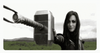 A Woman Is Holding A Giant Hammer In Her Hand . GIF