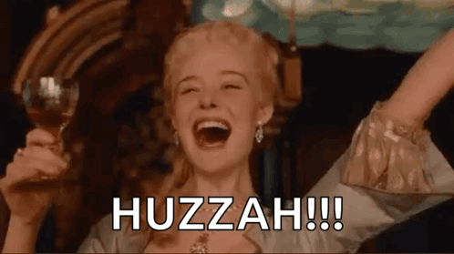 A Woman Is Holding A Glass Of Wine And Laughing With The Words Huzzah Written On The Screen . GIF