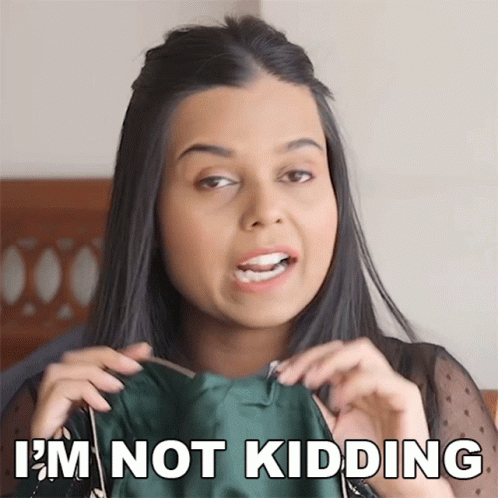 A Woman Is Holding A Green Dress And Says " I 'M Not Kidding " GIF