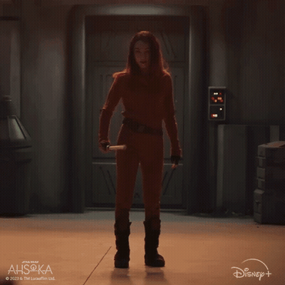 A Woman Is Holding A Green Lightsaber In Front Of A Disney Logo GIF