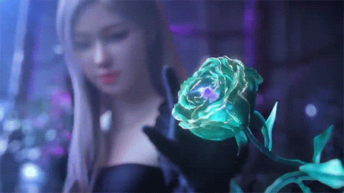 A Woman Is Holding A Green Rose In Her Hands . GIF