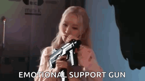 A Woman Is Holding A Gun In Her Hand . GIF