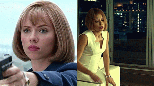 A Woman Is Holding A Gun Next To Another Woman Sitting On A Couch GIF