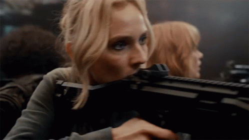 A Woman Is Holding A Gun With A Scope On It GIF