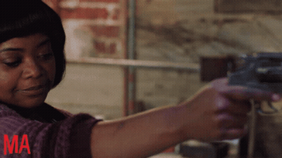 A Woman Is Holding A Gun With The Letter Ma In Red GIF