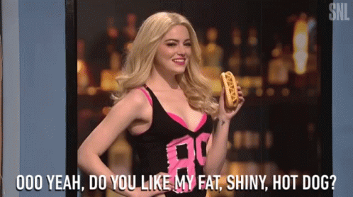 A Woman Is Holding A Hot Dog And Asking Do You Like My Fat Shiny Hot Dog GIF