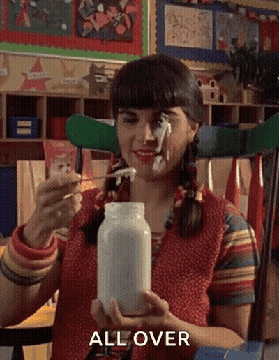 A Woman Is Holding A Jar Of Mayonnaise With A Spoon In Her Mouth And The Word All Over Is On The Bottom . GIF