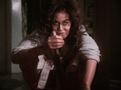 A Woman Is Holding A Knife In Her Hand And Smiling GIF