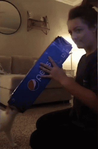 A Woman Is Holding A Large Pepsi Box GIF