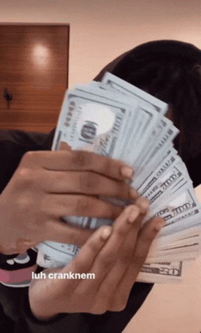 A Woman Is Holding A Large Stack Of Money In Her Hands . GIF