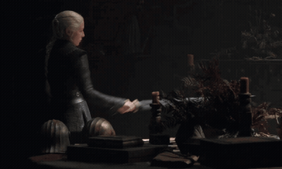 A Woman Is Holding A Large Sword In Her Right Hand GIF