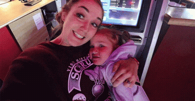 A Woman Is Holding A Little Girl Who Is Wearing A Shirt That Says ' Visit Histo ' On It GIF