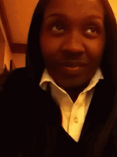 A Woman Is Holding A Lollipop In Her Hand GIF