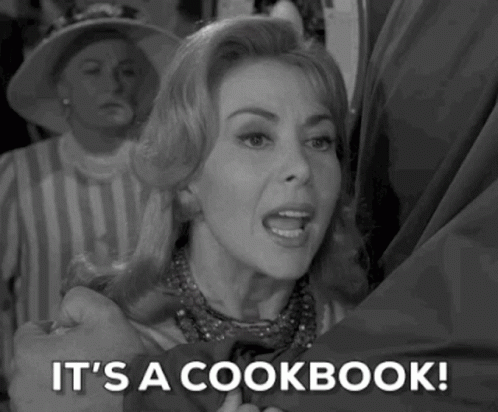 A Woman Is Holding A Man 'S Hand And Says `` It 'S A Cookbook '' . GIF