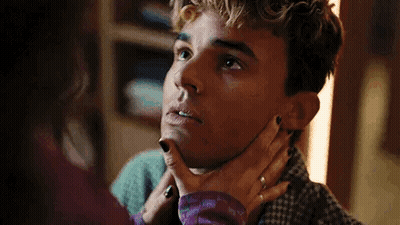 A Woman Is Holding A Man 'S Neck And Looking At Him . GIF