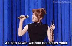 A Woman Is Holding A Microphone And Singing Into It . GIF