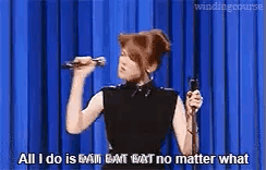 A Woman Is Holding A Microphone In Front Of A Blue Curtain And Saying `` All I Do Is Bat Bat No Matter What '' GIF