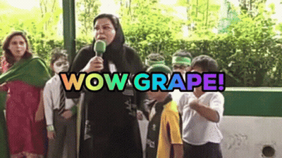 A Woman Is Holding A Microphone In Front Of A Group Of Children And The Words Wow Grape Are Above Her GIF