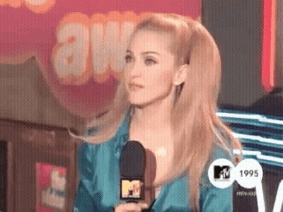 A Woman Is Holding A Microphone In Front Of A Mtv Logo GIF