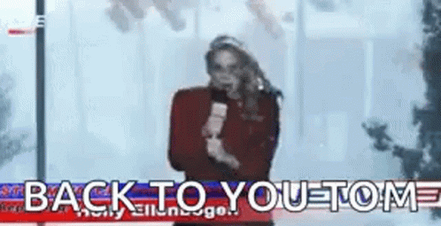 A Woman Is Holding A Microphone In Front Of A Sign That Says Back To You . GIF