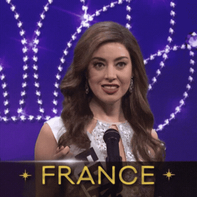 A Woman Is Holding A Microphone In Front Of A Sign That Says " France " GIF