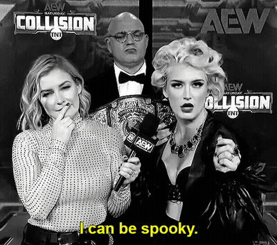 A Woman Is Holding A Microphone In Front Of A Sign That Says I Can Be Spooky GIF